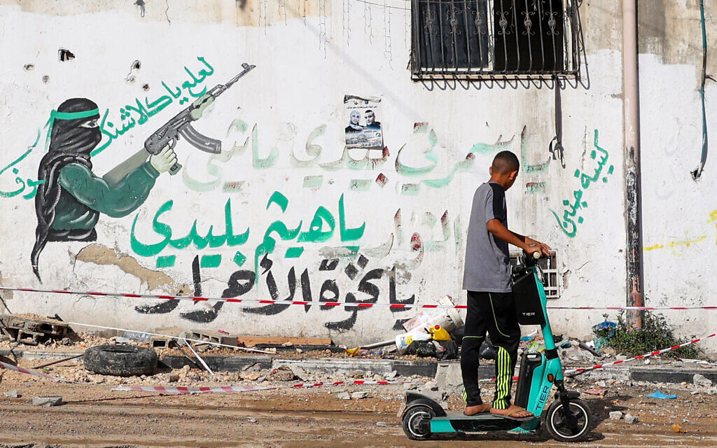 A Palestinian youth rides his scooter in the Tulkarem refugee camp in the West Bank on November 7, 2023, following an overnight raid by Israeli troops amid ongoing battles between Israel and the Hamas terror group. (Photo by Zain JAAFAR / AFP)