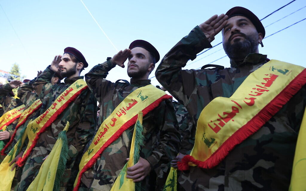 Members of the Lebanese Shiite terror group Hezbollah salute during the funeral of Youssef Karam Jawad, a gunman killed during cross-border clashes with Israel in the southern Lebanese village of Aita Al Shaab, on November 24, 2023. (Photo by AFP)