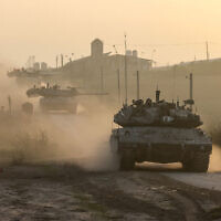 Israeli military vehicles drive near the border with the Gaza Strip on December 3, 2023. (Menahem KAHANA / AFP)
