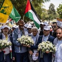 Nelson Mandela's grandson Mandla Mandela (3L) holds flowers along with Hamas official Basem Naim (2R) during a march to commemorate the 10th Anniversary of the death of former South African president Nelson Mandela in Pretoria, December 5, 2023, as Palestinian, Hamas and Hezbollah flags are waved. (Roberta Ciuccio / AFP)