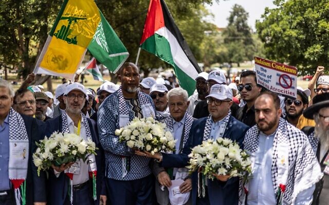 Nelson Mandela's grandson Mandla Mandela (3L) holds flowers along with Hamas official Basem Naim (2R) during a march to commemorate the 10th Anniversary of the death of former South African president Nelson Mandela in Pretoria, December 5, 2023, as Palestinian, Hamas and Hezbollah flags are waved. (Roberta Ciuccio / AFP)
