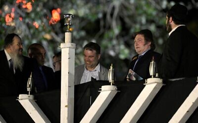 Rabbi Tzvi Grunblatt (L) and Argentina's President Javier Milei (2-R) gesture before lighting a giant menorah for Hanukkah, in Buenos Aires on December 12, 2023. (Juan Mabromata/AFP)