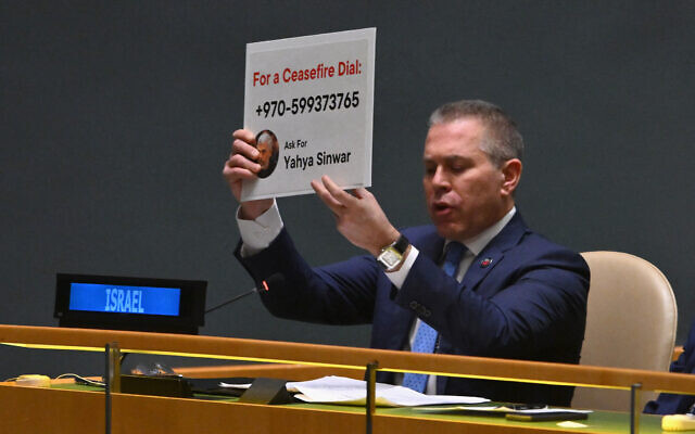 Israeli Ambassador to the United Nations Gilad Erdan holds up a Hamas phone number during the UN General Assembly vote on a non-binding resolution demanding "an immediate humanitarian ceasefire" in Gaza, at UN headquarters in New York, on December 12, 2023. (Angela Weiss/AFP)