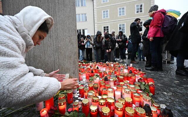 Well wishers light candles in memory of the victims outside the Charles University in central Prague, on December 22, 2023, as police investigators kept working on the campus the day after a deadly mass shooting (Michal Cizek / AFP)