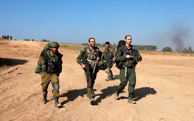 IDF soldiers walk near the border with the Gaza Strip in Israel on their return from the Gaza Strip, on December 31, 2023, amid continuing battles between Israel and the terror group Hamas. (Menahem Kahana / AFP)