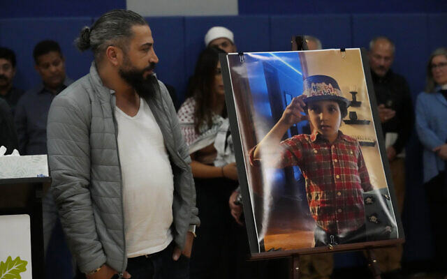 Wadea Al Fayoume's father, Oday Al Fayoume, looks at a photo of his son Wadea Al Fayoume during a vigil at Prairie Activity and Recreation center in Plainfield, Ill., October 17, 2023. (AP Photo/Nam Y. Huh)