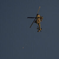 An Israeli Apache helicopter fires flares over the Gaza Strip on Friday, Dec. 1, 2023. (AP/Ariel Schalit)