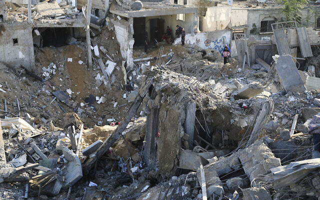 Palestinians look at destruction after an Israeli strike in Rafah, southern Gaza Strip, December 4, 2023. (AP Photo/Hatem Ali)
