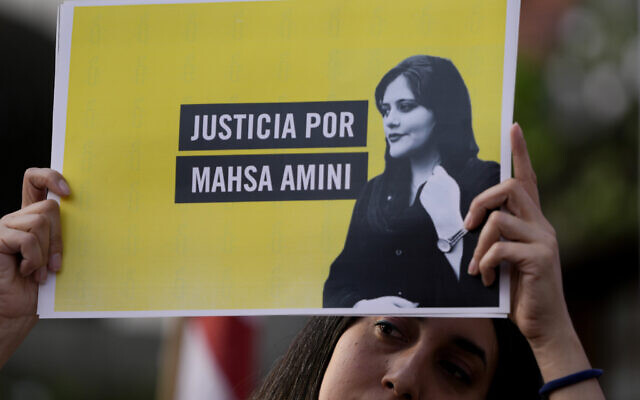 FILE - A woman holds a sign that reads in Spanish "Justice for Mahsa Amini" as she protests against the death of Amini, an Iranian woman who died while in police custody in Iran, in front of the Iranian embassy in Buenos Aires, Argentina, September 27, 2022. (AP Photo/Natacha Pisarenko, File)