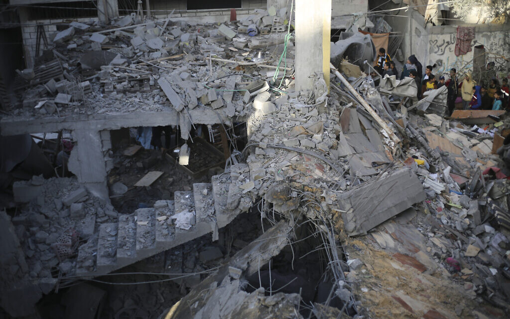 Palestinians look at the destruction after an Israeli strike in Rafah, Gaza Strip, December 24, 2023. (AP Photo/Hatem Ali)