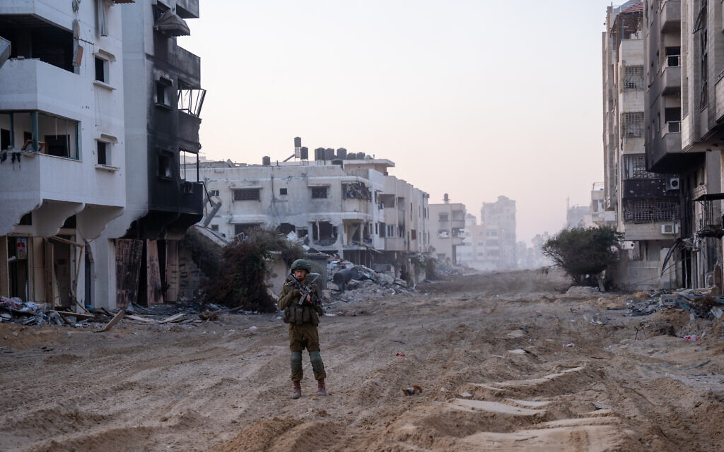 Солдат ЦАХАЛа стоит на страже возле площади Палестины в районе Римал в городе Газа, 19 декабря 2023 года. (Эмануэль Фабиан/Times of Israel)