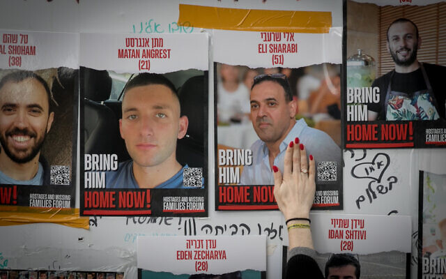 Israelis put up posters of hostage held by Hamas terrorists in Gaza, at 'Hostages Square' in Tel Aviv. December 6, 2023. (Miriam Alster/FLASH90)