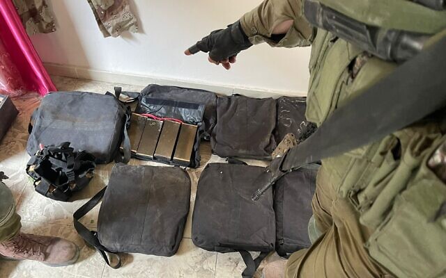 Солдат ЦАХАЛ указывает на то, что, по словам армии, является жилетом со взрывчаткой, пригодным для использования ребенком, который был обнаружен солдатами на севере сектора Газа 24 декабря 2023 года. (Силы обороны Израиля)