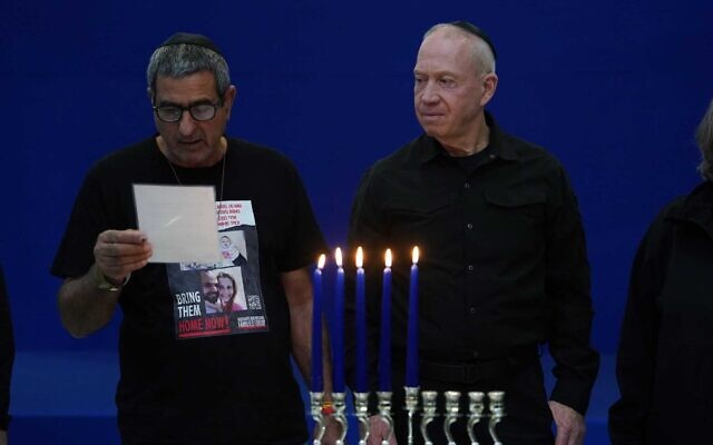 Defense Minister Yoav Gallant lights Hanukkah candles in Tel Aviv with family members of hostages, December 10, 2023. (Ariel Hermoni/Defense Ministry)