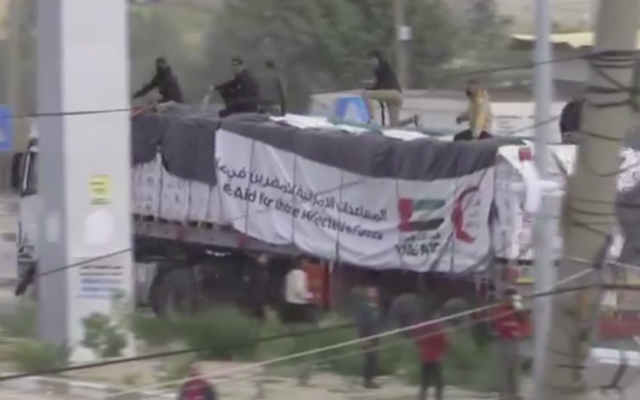 Armed, masked men reportedly affiliated with Hamas can be seen atop trucks carrying humanitarian aid that arrived in the Gaza Strip via Egypt's Rafah crossing, December 17, 2023. (Screenshot, used in accordance with Clause 27a of the Copyright Law)