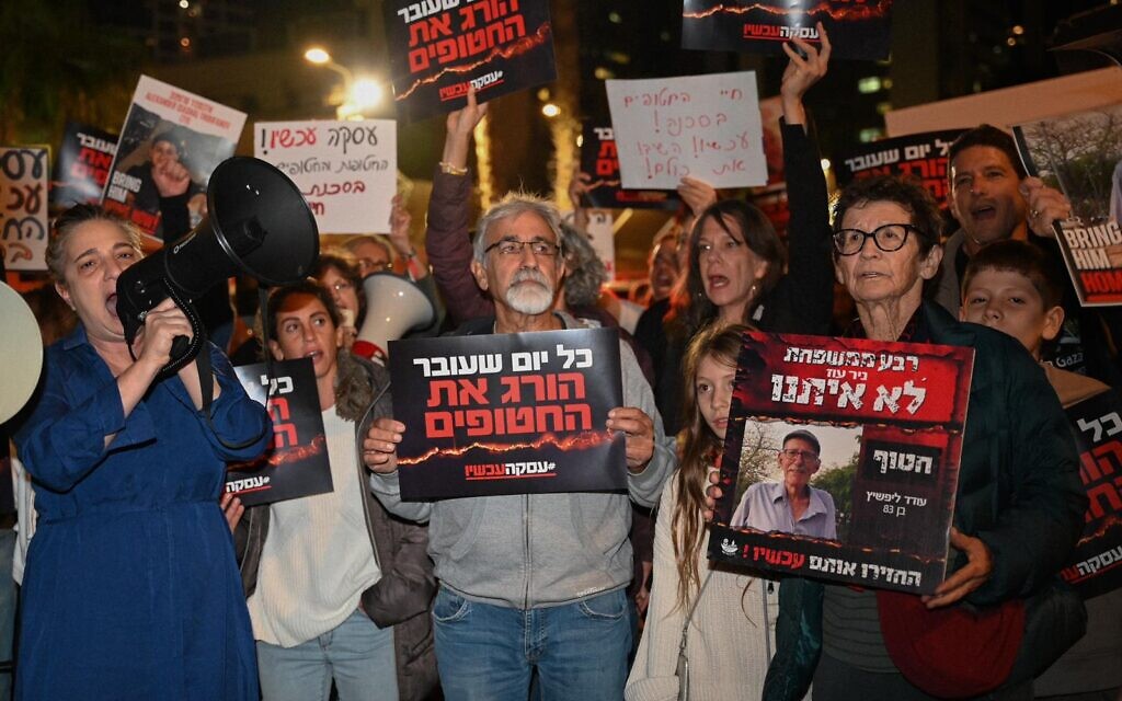 Released hostage Yocheved Lifshitz (right) attends a rally for the return of all hostages from Gaza, at 'Hostages Square' in Tel Aviv, December 9, 2023. One of the signs reads: "Each passing day is killing the hostages." (Lior Segev)
