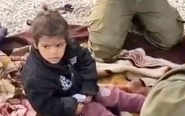 A four-year-old Palestinian girl is treated by IDF reserve soldiers after getting lost and falling asleep inside an IDF encampment in the Gaza Strip in a still from a video dated December 10, 2023. (Screenshot, Zman Yisrael)