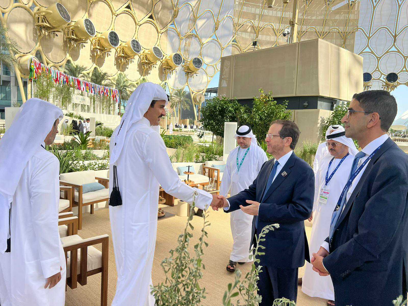 Israel's President Isaac Herzog (3rd right) shakes hands with Qatari Emir Tamim bin Hamad Al Thani on the sidelines of the COP28 summit in Dubai, December 1, 2023 (Courtesy)