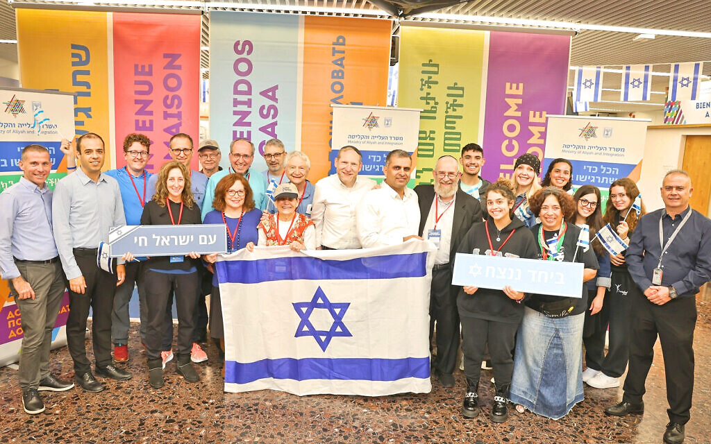 Israeli Immigration Minister Ofir Sofer poses at Ben-Gurion Airport with some of the 25 new immigrants who arrived from New York on October 19, 2023, less than two weeks after Israel was thrust into war. (Courtesy: Nefesh B’Nefesh)