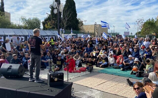 Ronni Neeman, whose niece was murdered by Hamas terrorists on October 7, speaks at a rally calling for the ouster of Prime Minister Benjamin Netanyahu, December 8, 2023 (Times of Israel)