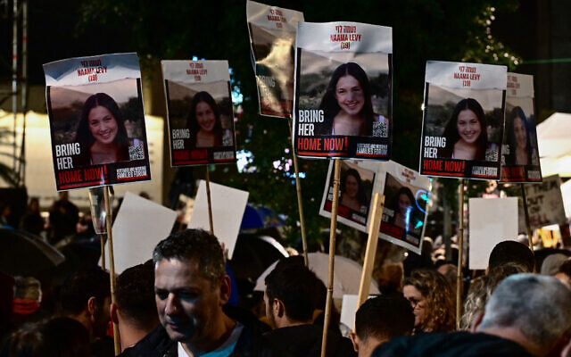Protesters lift protraits of hostage Naama Levy during a rally for supporters and relatives of Israelis held in Gaza since October 7, in Tel Aviv on December 23, 2023. (Alberto PIZZOLI / AFP)