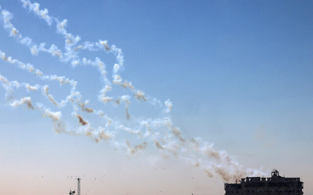 The smoke of rockets fired from the Gaza Strip toward Israel lingers above a building on January 7, 2024. (AFP)