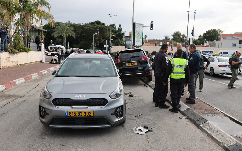 Israeli emergency and security personnel stand next to a damaged car following a suspected ramming attack in the central town of Ra'anana، on January 15، 2024. (JACK GUEZ / AFP)