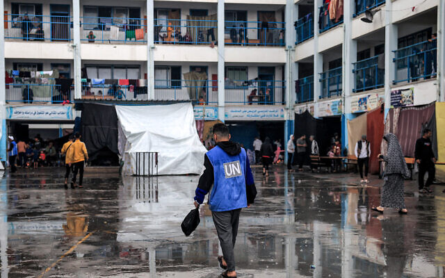 A man walks with a vest bearing the logo of the UN at a school run by UNRWA in Rafah in the southern Gaza Strip on November 14, 2023 (Said Khatib/AFP)
