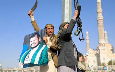 Illustrative: Fighters loyal to Yemen's Houthi rebels, stand guard during a protest following US and British strikes in the Houthi-controlled capital Sana'a on January 12, 2024. (Mohammed Huwais/AFP)