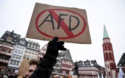 A demonstrator holds a placard with a barred AfD sign referring to Germany's far-right Alternative for Germany (AfD) party during a demonstration against racism and far right politics in Frankfurt am Main, western Germany on January 20, 2024. (Photo by Kirill KUDRYAVTSEV / AFP)