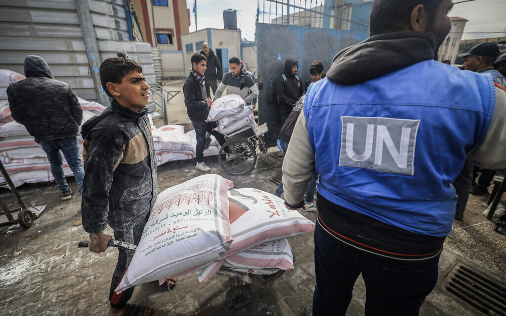Displaced Palestinians receive food aid at the United Nations Relief and Works Agency for Palestine Refugees (UNRWA) center in Rafah in the southern Gaza Strip on January 28, 2024. (AFP)