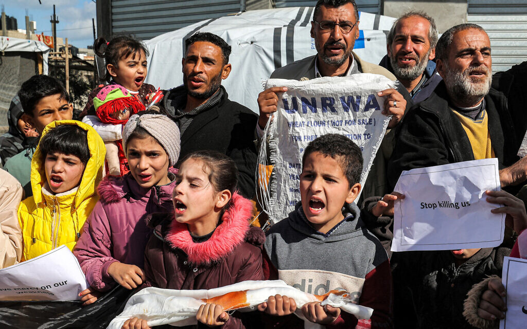 Palestinian men and children gather for a demonstration in Rafah in the southern Gaza Strip on January 30, 2024, calling for continued international support to the United Nations Relief and Works Agency UNRWA. (Photo by AFP)