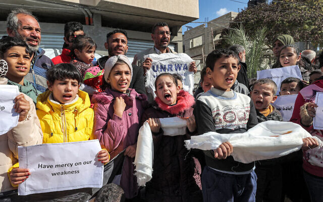 Palestinian men and children gather for a demonstration in Rafah in the southern Gaza Strip on January 30, 2024, calling for continued international support to the United Nations Relief and Works Agency, UNRWA. (AFP)
