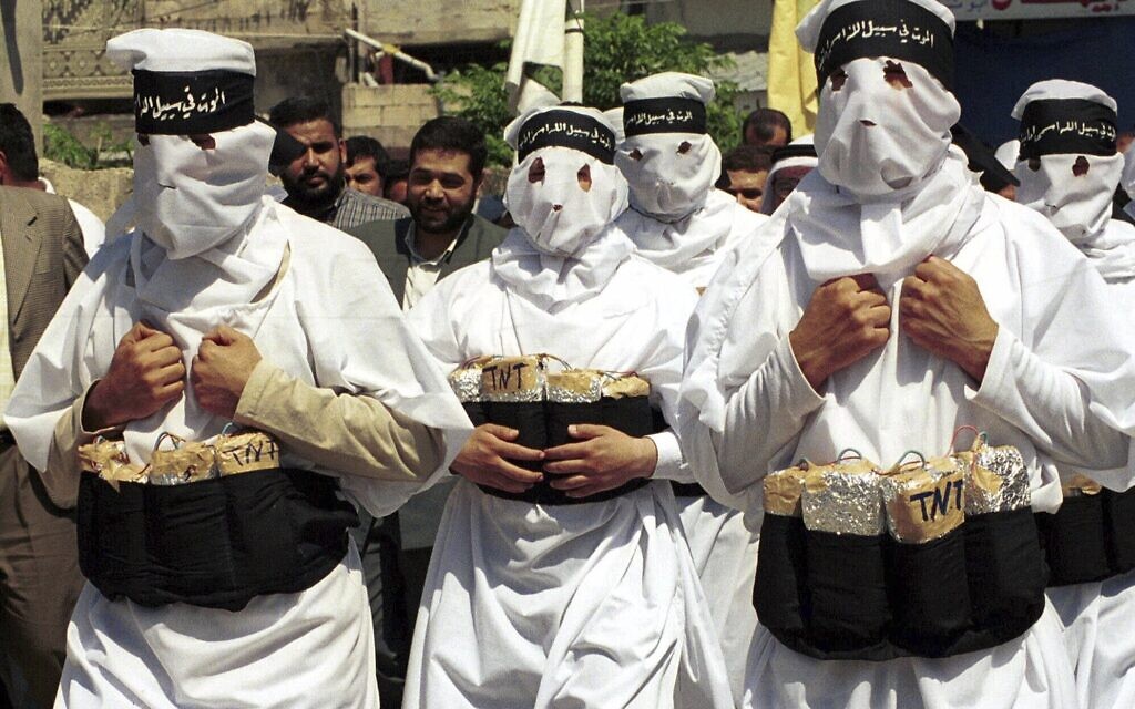 Hamas terror group supporters wearing fake explosives and black headbands reading 'Death for the sake of God,' march during a demonstration in the southern port city of Tyre, Lebanon, April 13, 2001. (AP Photo/Mohamed Zatari, File)