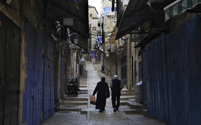 Palestinians walk past closed shops in the Old City of Jerusalem, Monday, Oct. 16, 2023. (AP Photo/Jon Gambrell)