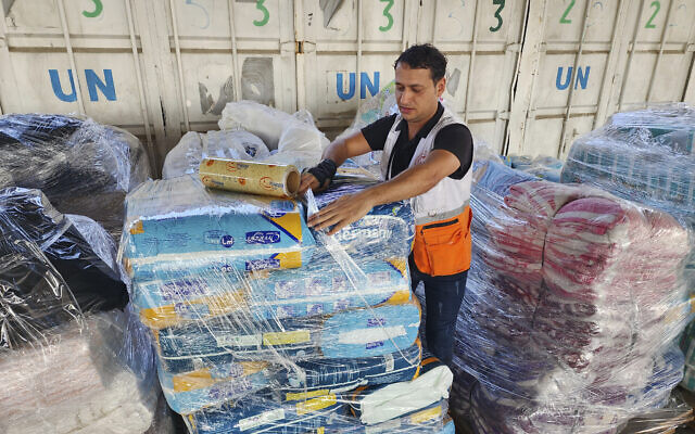 United Nations and Red Crescent workers prepare the aid for distribution to Palestinians at UNRWA warehouse in Deir Al-Balah, Gaza Strip, on Oct. 23, 2023. (AP Photo/Hassan Eslaiah)