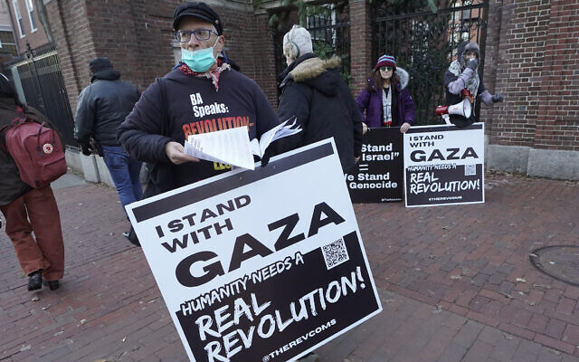 George Stevens, of Cambridge, Massachusetts, front, hands out leaflets to passers-by near an entrance to Harvard University, December 12, 2023, while joining with anti-Israel, pro-Palestinian demonstrators. (AP Photo/Steven Senne)