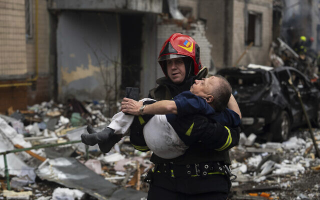 A firefighter carries a man from a damaged residential building after a Russian missile strike, in Kyiv, Ukraine, Tuesday, Jan. 2, 2024. (AP Photo/Alex Babenko)