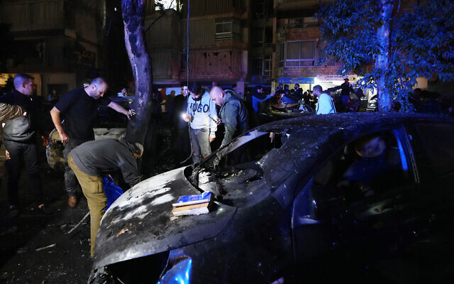 People inspecting body parts following a massive explosion in the southern suburb of Beirut, Lebanon, on Tuesday, January 2, 2024. (AP Photo/Hassan Ammar)