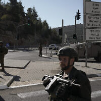 Israeli soldiers stand guard next to the scene of a Palestinian shooting attack, near Wadi al-Haramiya, West Bank, January 7, 2024. (AP Photo/Leo Correa)