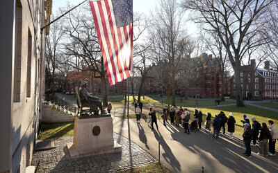 People take photos near a John Harvard statue, left, on the Harvard University campus, Tuesday, Jan. 2, 2024, in Cambridge, Massachusetts. (AP Photo/Steven Senne, File)