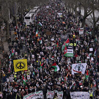 Protesters hold up banners, flags and placards as they walk along the Embankment by the River Thames during an anti-Israel demonstration, in London, January 13, 2024. (AP Photo/Alberto Pezzali)