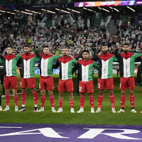 The Palestinian team stands for its national anthem ahead of the Asian Cup Group C soccer match between Iran and Palestine at the Education City Stadium in Al Rayyan, Qatar, January 14, 2024. (AP Photo/Aijaz Rahi)