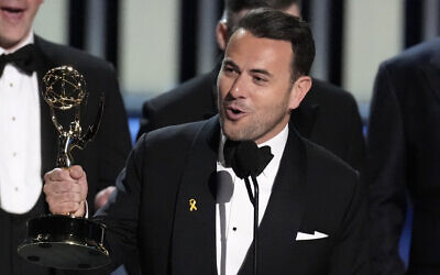 Ben Winston accepts the award for outstanding variety special (live) for 'Elton John Live: Farewell from Dodger Stadium' during the 75th Primetime Emmy Awards at the Peacock Theater in Los Angeles, January 15, 2024. On his lapel is a yellow ribbon pin highlighting the hostages held by terror group Hamas in the Gaza Strip.  (Chris Pizzello/AP)