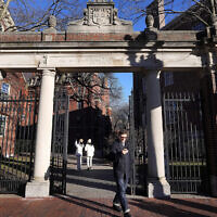 File: A passerby walks through a gate to the Harvard University campus in Cambridge, Massachusetts, January 2, 2024. (Steven Senne/AP Photo)