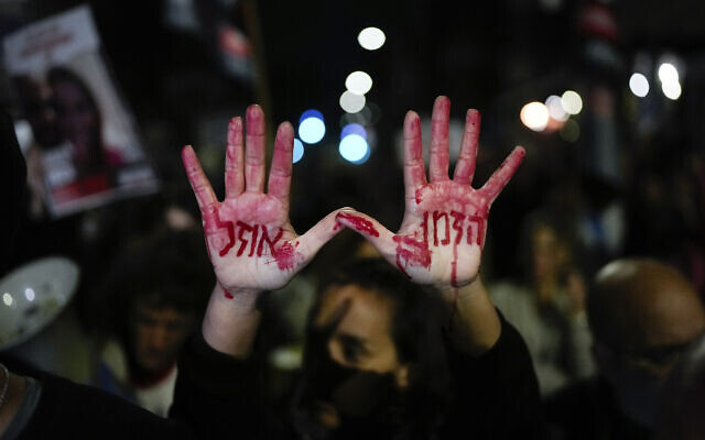 Relatives and supporters of the Israeli hostages held in the Gaza Strip by  Hamas attend a protest calling for their release outside the Knesset, Israel's parliament, in Jerusalem, Jan. 22, 2024. Hebrew on the hands with fake blood reads, 'Time is running out.'. (AP Photo/Ohad Zwigenberg)