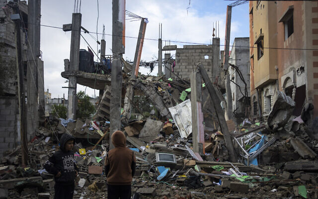 Palestinians look at the destruction after an apparent Israeli strike in Rafah, southern Gaza Strip, Saturday, Jan. 27, 2024. (AP Photo/Fatima Shbair)