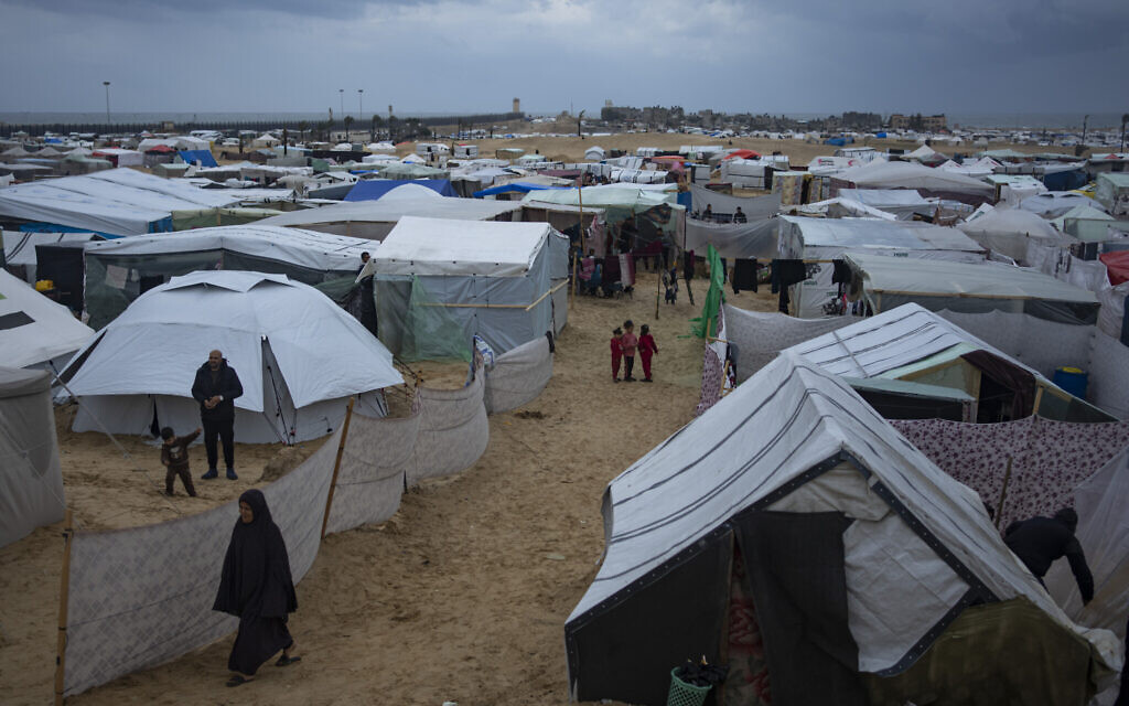Palestinians displaced by the Israeli offensive against Hamas in the Gaza Strip walk through a makeshift tent camp in Rafah on Saturday, Jan. 27, 2024. (AP/Fatima Shbair)