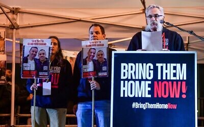 Joseph Avi Yair Engel, right, whose parents were Holocaust survivors and whose grandson was released from captivity in Gaza, speaks at rally calling for the release of the remaining hostages, in Hostages Square in Tel Aviv on January 27, 2024. (Avshalom Sassoni/Flash90)