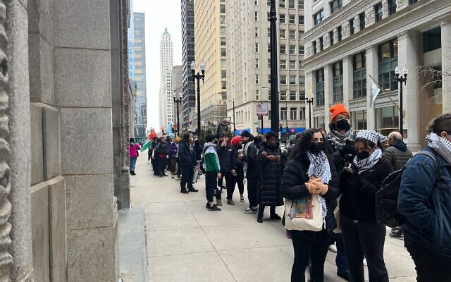Pro-Palestinian activists line up to enter Chicago City Hall for a meeting on a resolution calling for a ceasefire in Gaza on January 31, 2024. (Jacob Magid/Times of Israel)